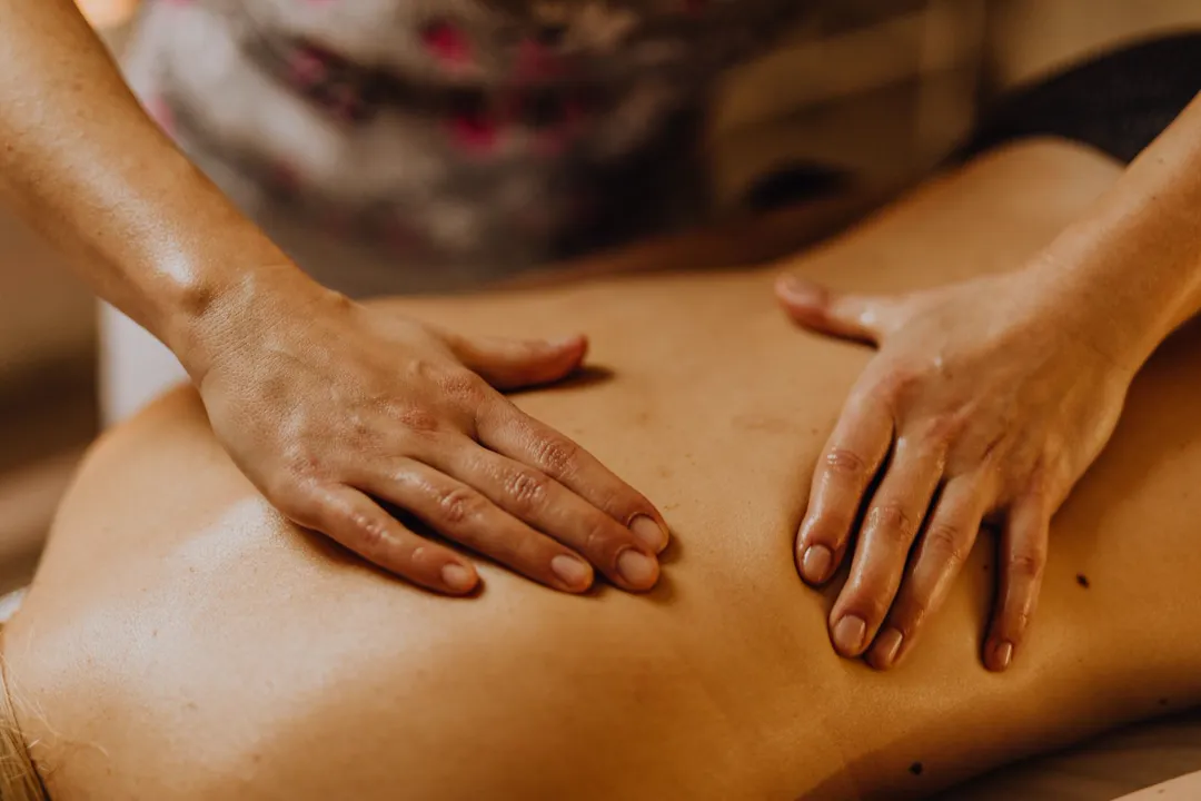 Practitioner's hands gliding a cup along the upper back